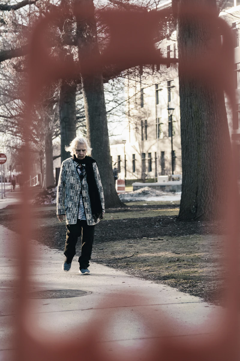 Active senior woman walking independently outdoors along a tree-lined path